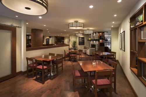 加蒂诺Four Points by Sheraton Hotel & Conference Centre Gatineau-Ottawa的用餐室配有木桌和椅子