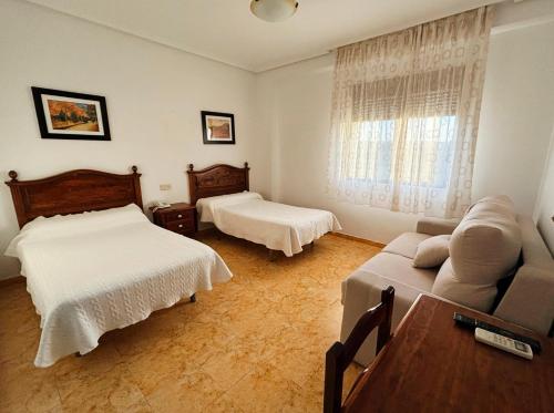 巴萨Hotel Restaurante Dama de Baza的一间带两张床和一张沙发的客厅