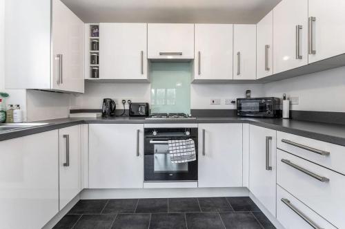 爱丁堡GuestReady - O Beehive em Edimburgo的白色的厨房配有白色橱柜和电器
