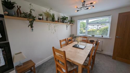 Saint BlazeyChy Lowen Private rooms with kitchen, dining room and garden access close to Eden Project & beaches的一间带木桌和椅子的用餐室