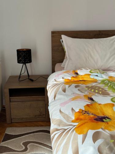 蒂米什瓦拉Apartament Victoria的床头柜旁的一张带花 ⁇ 的床