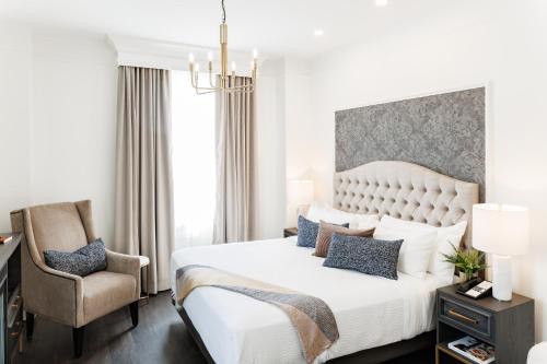 夏洛特顿罗德夏洛特敦酒店的卧室配有一张白色大床和一把椅子