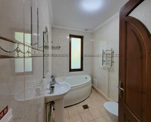 特鲁斯卡韦茨Glory的白色的浴室设有浴缸和水槽。
