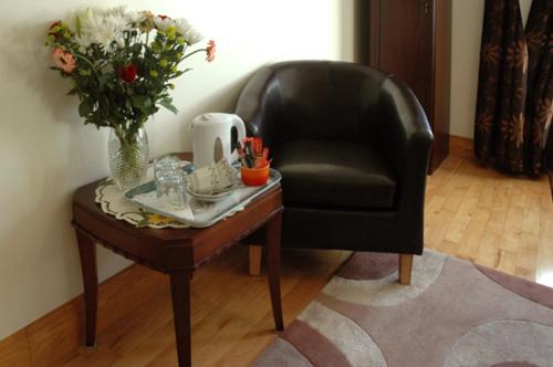班克拉那Caldra B&B的一张黑椅子和一张带花瓶的桌子
