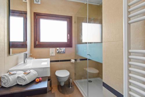 卡武埃鲁Vale de Milho Village的一间带水槽、卫生间和玻璃淋浴间的浴室