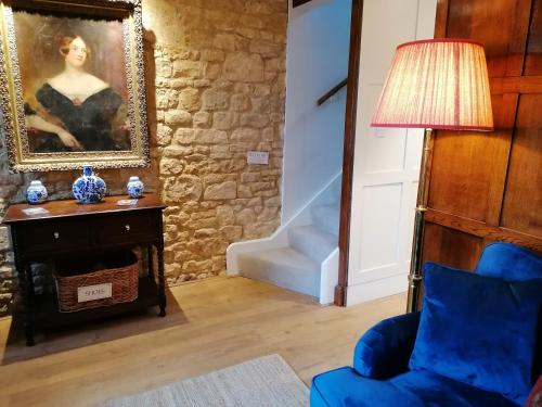奇平卡姆登Merriman Cottage的客厅配有蓝椅和绘画
