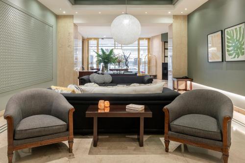 布宜诺斯艾利斯安再尼卡塔套房酒店 的客厅配有沙发和两把椅子