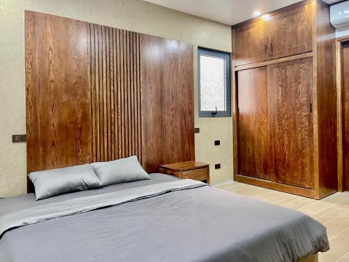 Green Bay Luxury Villa Sonasea Vân Đồn的一间卧室设有一张床和木墙