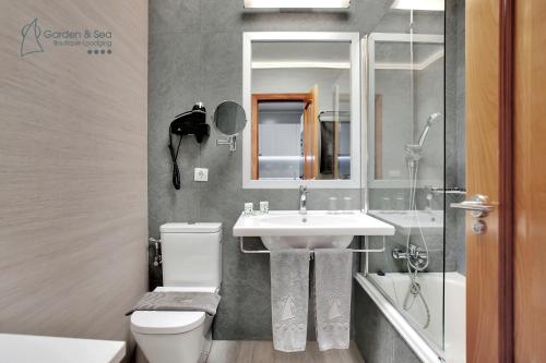 莫罗德哈布雷Apartamentos Garden & Sea Boutique Lodging by LIVVO的一间带水槽、卫生间和镜子的浴室