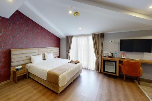 伊斯坦布尔King City Hotel的一间卧室设有一张红色墙壁的大床