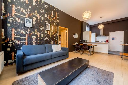 布鲁塞尔Smartflats City - Brusselian的一间带蓝色沙发的客厅和一间厨房