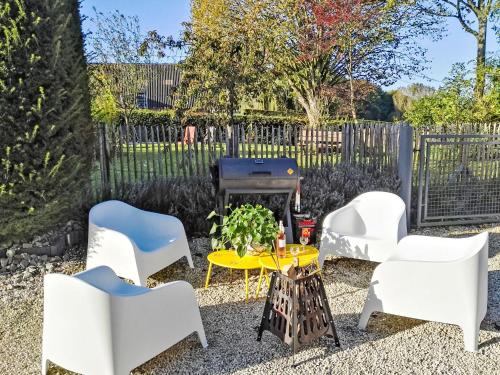 EllezellesHoliday Home Gîte L'Archipel by Interhome的庭院配有白色的椅子和烧烤架。