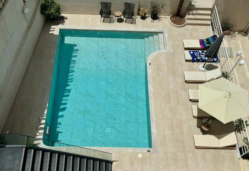 赫索尼索斯福拉瑞酒店的享有带椅子和遮阳伞的游泳池的顶部景致