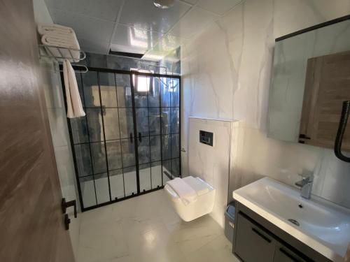 马尔马拉Avsa Artemis Hotel的白色的浴室设有卫生间和水槽。