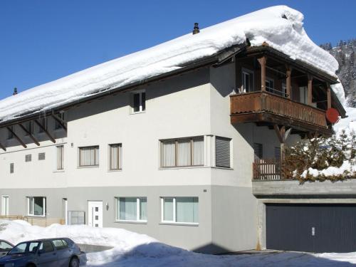 库尔瓦尔登Apartment Honegger by Interhome的一座带雪盖的建筑,上面设有一个阳台