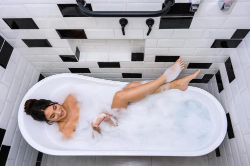 隆德里纳Apto Londrina Flat Hotel jacuzzi 43 m2的躺在浴缸中的女人