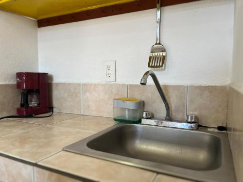 圣路易斯波托西INMOTEGA - Suites TG的厨房水槽和悬在上面的spatula