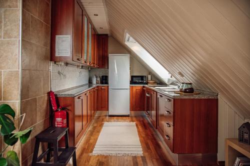 奥勒松Panorama Apartment Ålesund的厨房配有木制橱柜和白色冰箱。