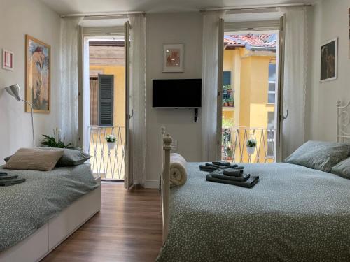 因特拉Holiday Studio in Centro Storico Intra的一间卧室配有两张床和一台平面电视