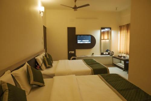 奇克马格尔Joldal Residency的酒店客房设有两张床和电视。