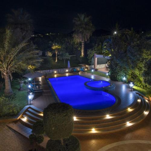 斯塔罗斯Villa Elina Luxury Residence的夜间游泳池周围灯光环绕