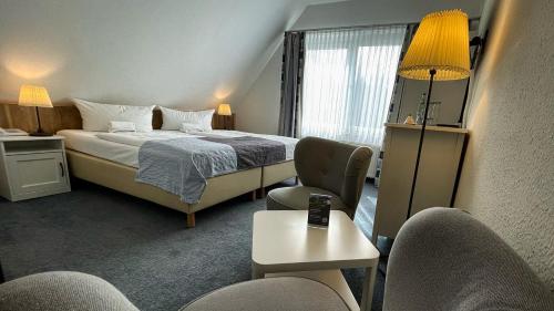 青斯特希尔库鲁克餐厅&酒店的酒店客房带一张床、一张桌子和椅子