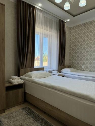博孔巴耶沃Айкол的一间卧室设有两张床和窗户。