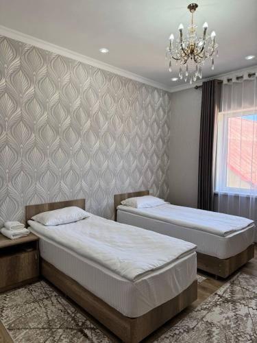 博孔巴耶沃Айкол的一间卧室配有两张床和吊灯。