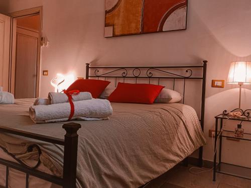 蓬泰代拉Il Casale di David的一间卧室配有一张带两个红色枕头的床