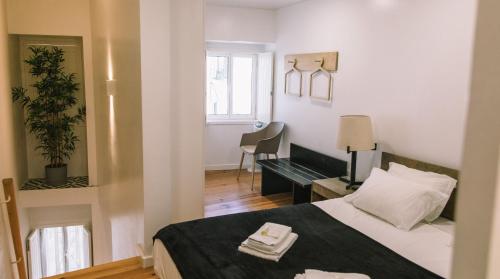 里斯本Casa da Maria Alfama的一间卧室配有一张床、一张书桌和一个窗户。