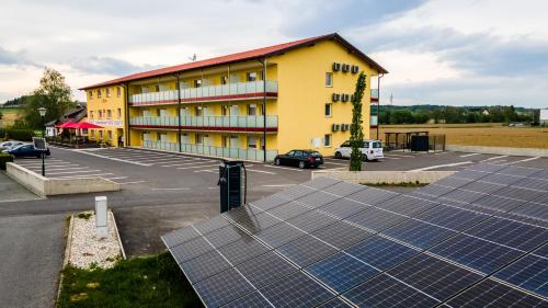 莱布尼茨Hotel Vulkan Residenz - Self-Check-in的停车场前的一栋带太阳能电池板的建筑