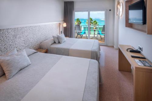 圣苏珊娜Caprici Beach Hotel & Spa的酒店客房设有两张床,享有海景。