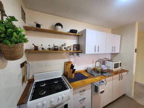 CaraballedaRitasol Palace apartamento de relax frente al mar的厨房配有白色橱柜和炉灶烤箱。