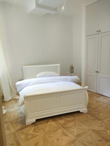 诺丁汉Versailles的白色卧室铺有木地板,配有白色的床。