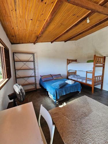 卡兰卡斯Sítio Mata Virgem的一间卧室设有两张床和木制天花板