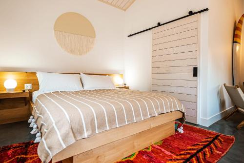 斯廷森海滩Longboard Studio includes King Bed and Kitchenette的一间卧室配有一张大床和木制床头板