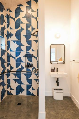 斯廷森海滩Longboard Studio includes King Bed and Kitchenette的浴室设有蓝色和白色图案的淋浴帘