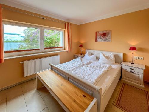 马林费尔德Ferienhaus Seemannsruh Wohnung mit Wasserblick und abgeschlossenem Grundstück的一间卧室设有一张大床和一个窗户。