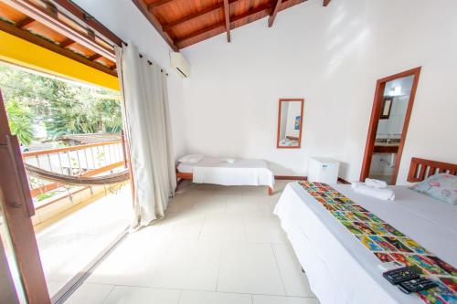 阿拉亚尔达茹达Pousada Flor do Arraial的一间带两张床的卧室和一个阳台