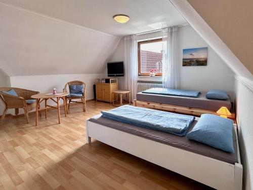 RickenbachFerienhaus Pfänderblick的一间卧室配有两张床和一张桌子及椅子