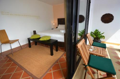 卡马拉海滩爬爬螃蟹精品旅馆的配有一张床和一张桌子及椅子的房间