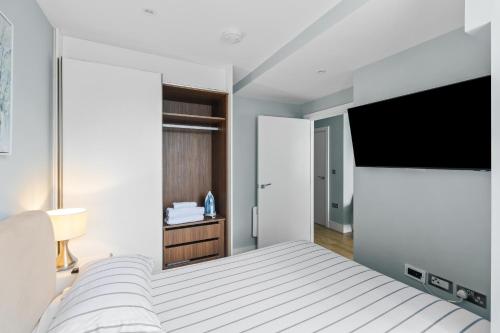切姆Luxurious One Bedroom Apartment in Bond Street的一间卧室配有一张床和一台平面电视