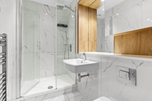切姆Luxurious One Bedroom Apartment in Bond Street的带淋浴和盥洗盆的白色浴室