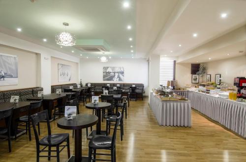雅典爱玛仕酒店的一间带桌椅的餐厅和一间酒吧