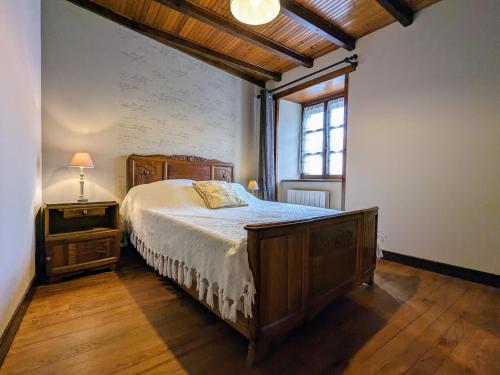 Saint-IlpizeGîte Saint-Ilpize, 3 pièces, 4 personnes - FR-1-582-93的一间卧室设有一张木床和一个窗户。