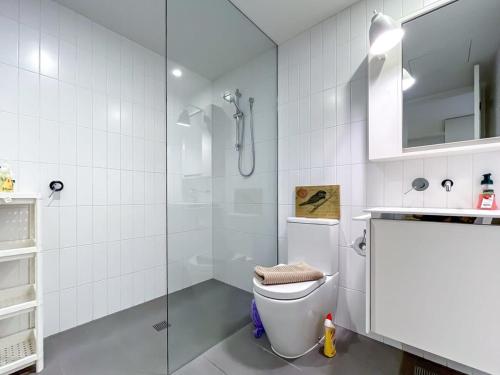 墨尔本BPM Brighton APT with Garden LG1的白色的浴室设有卫生间和淋浴。