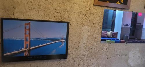 帕拉蒂Chales Internacional的挂在墙上的电视,挂着金门桥的照片