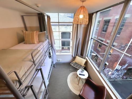 墨尔本墨尔本欧洲旅舍的宿舍间设有双层床和窗户。