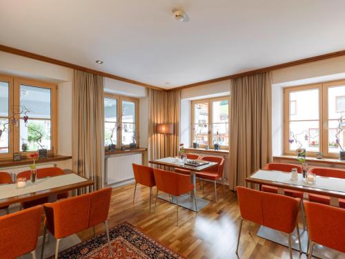 圣安东阿尔贝格Quality Hosts Arlberg - Hotel Goldenes Kreuz B&B的餐厅设有桌椅和窗户。