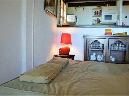 勒拉旺杜Maison Le Lavandou, 2 pièces, 5 personnes - FR-1-251-566的一间卧室,配有一张带红色台灯的床铺